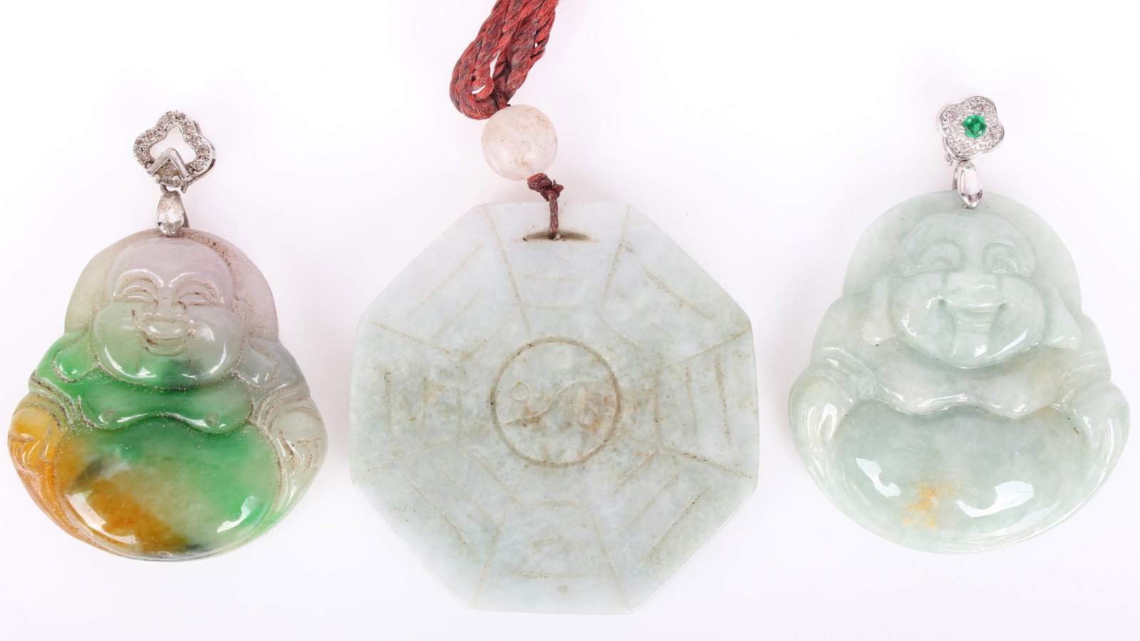 CHINESE JADEITE CARVED PENDANTS - LOT OF 3: CHINESE JADEITE CARVED PENDANTS - LOT OF 3 Chinese jadeite carved amulet pendants to include 2 Buddha pendants and 1 octagonal yin yang pendant. Size: 2" Largest