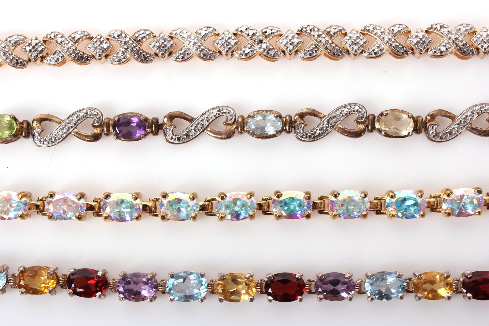 STERLING SILVER LADIES GEMSTONE BRACELETS (4): 97082STERLING SILVER LADIES GEMSTONE BRACELETS (4) Sterling silver .925 ladies gemstone bracelets to include one cross pattern marcasite bracelet, one bracelet with amethyst, aquamarine, topaz, and ci