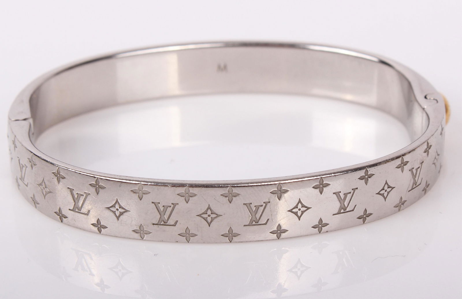 LOUIS VUITTON NANOGRAM CUFF BRACELET: 97123LOUIS VUITTON NANOGRAM CUFF BRACELET Ladies Louis Vuitton Nanogram cuff bracelet made of brass with a palladium finish. "Italy M00250 LE1116" inscribed on the inside along with a single "M" and "