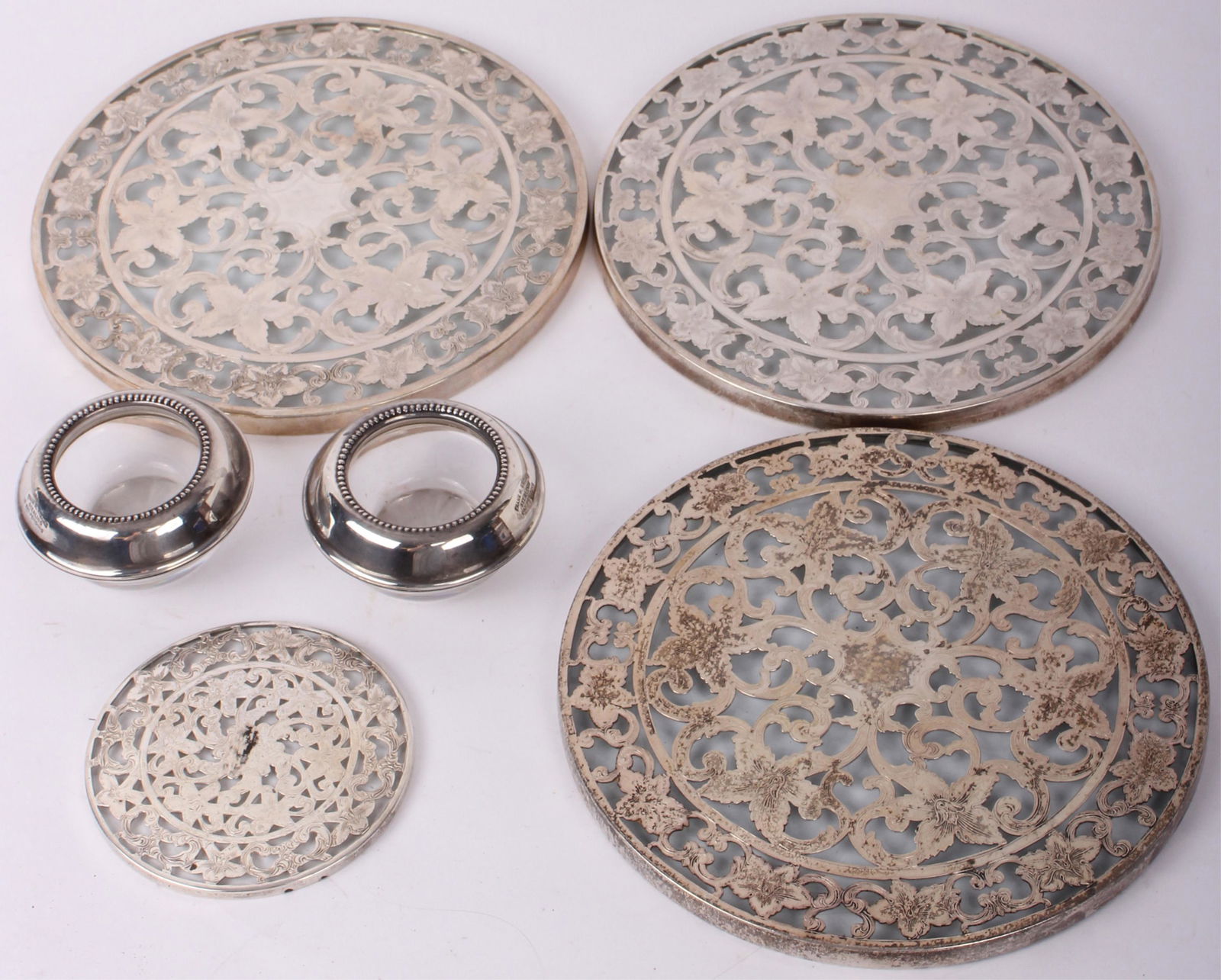 .925 SILVER INLAY W/ GLASS TRIVETS, COASTERS, ETC.: 97160.925 SILVER INLAY W/ GLASS TRIVETS, COASTERS, ETC. Three sterling silver inlay with glass trivets and one silver inlay with glass coaster and two Frank M. Whiting sterling candle holders with gla