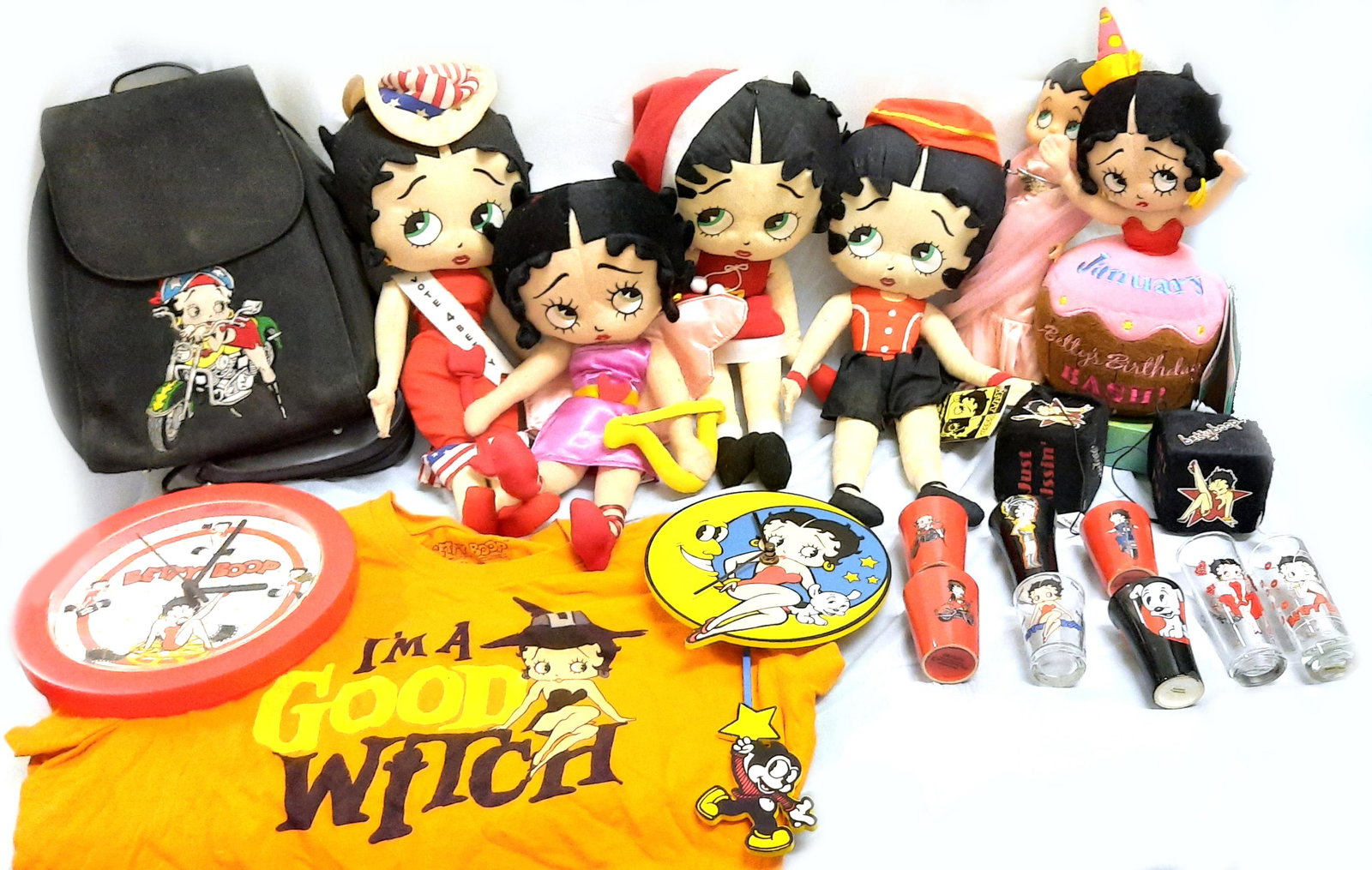 BETTY BOOP COLLECTIBLES - CLOCKS, DOLLS, GLASSES: 97311BETTY BOOP COLLECTIBLES - CLOCKS, DOLLS, GLASSES Betty Boop collectibles to include 8 assorted shot glasses, 2 wall clocks, 6 assorted stuffed dolls, a pair of Betty Boop fuzzy dice, a childrens 