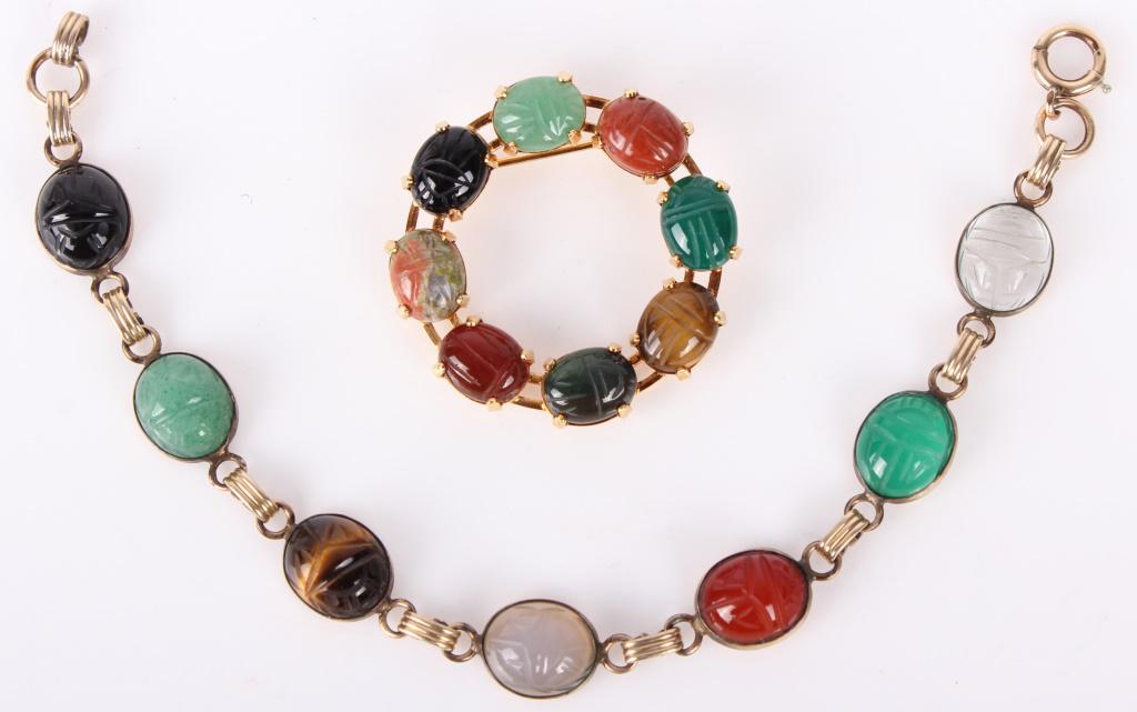 LADIES YELLOW GOLD FILLED SCARAB BRACELET& BROOCH: LADIES YELLOW GOLD FILLED SCARAB BRACELET& BROOCH To include: a ladies gold filled multiple cut gemstone link bracelet (7")and a ladies gold plated scarab beetle cut stone brooch (1.5"). Weight: 21.4