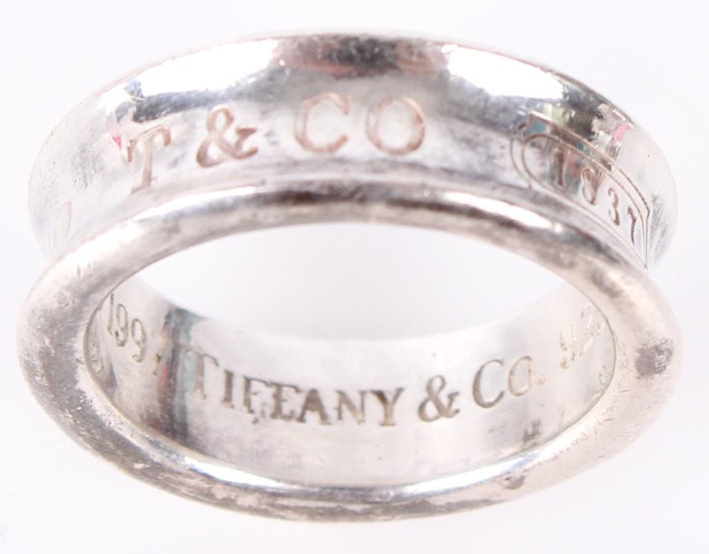 TIFFANY & CO STERLING SILVER WEDDING BAND: TIFFANY & CO STERLING SILVER WEDDING BAND Unisex sterling silver Tiffany and Company wedding ring, marked on outside of band "{925} T&CO {1837}". Stamped interior "Copyright 1997 Tiffany & Co. 925" We