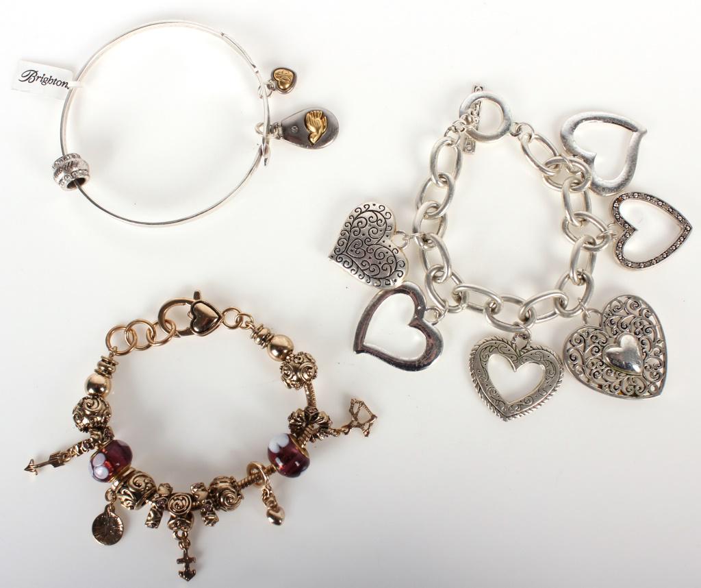 BRIGHTON CHARM BRACELETS W/ ORIGINAL TAG - (3): BRIGHTON CHARM BRACELETS W/ ORIGINAL TAG - (3) Set of Brighton charm bracelets to include one bracelet with a charm that says "Peace on Earth", another that says "wow," one chain bracelet with six hea