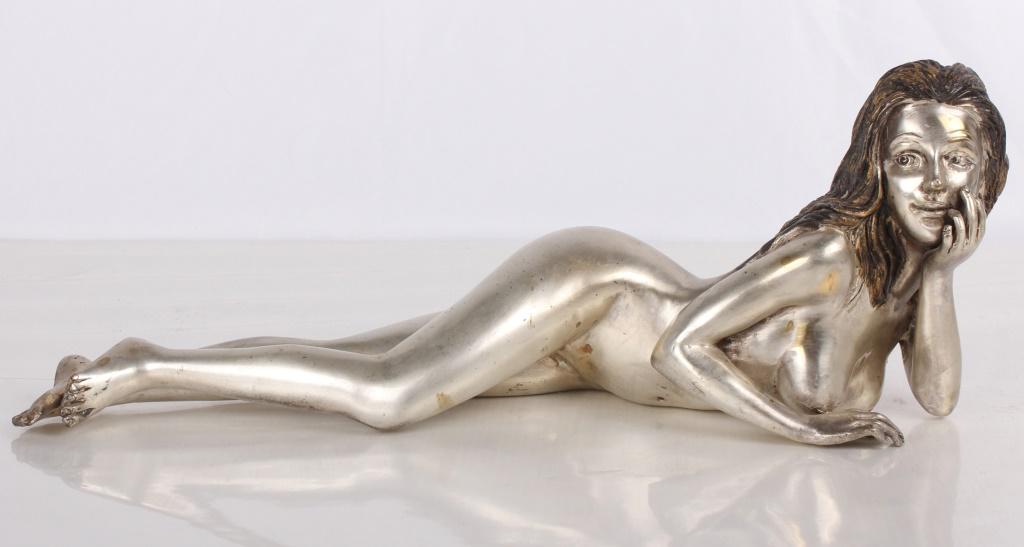 BRONZE SILVER TONED RECLINING WOMAN NUDE SCULPTURE: BRONZE SILVER TONED RECLINING WOMAN NUDE SCULPTURE Bronze silver-toned nude reclining woman sculpture. The woman is laying down and propping her head up on her hand. Unsigned. Size: 14.5" Long Conditi