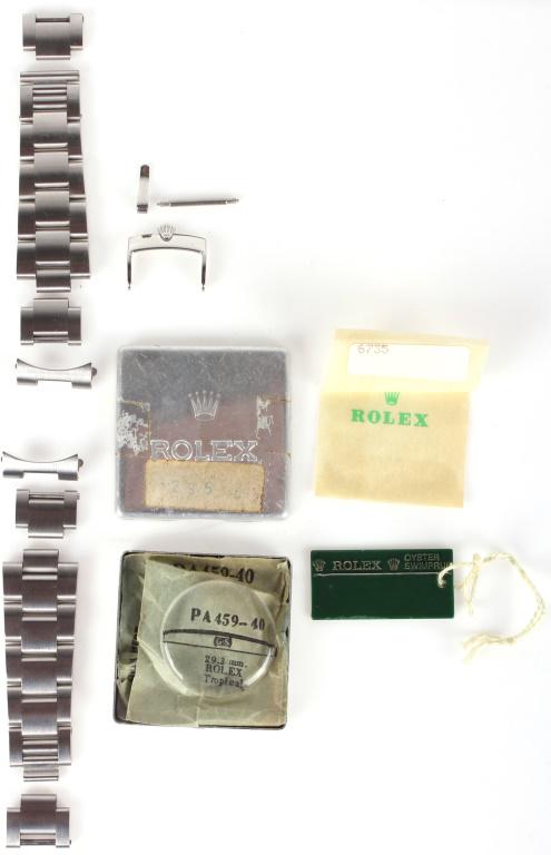 ROLEX ACCESS: TROPICAL 29.3MM CRYSTAL, ROLEX CLASP: 10477ROLEX ACCESS: TROPICAL 29.3MM CRYSTAL, ROLEX CLASP Rolex accessories to include a 29.3mm Rolex Tropical small sapphire crystal with original sleeve and aluminum Rolex case, a Rolex clasp, a Rolex