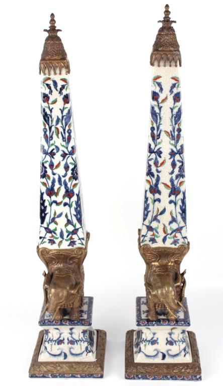 CASTILIAN DESIGNER PORCELAIN OBELISKS (2): 11089CASTILIAN DESIGNER PORCELAIN OBELISKS (2) Castilian designer porcelain obelisks to include 2 ornately decorated majestic elephants. One cracked on base, re-glued. Size: Approx. 25"Condition: See