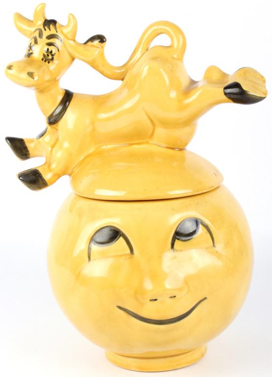 MID-CENTURY COW JUMPED OVER THE MOON COOKIE JAR: 11090MID-CENTURY COW JUMPED OVER THE MOON COOKIE JAR American porcelain cookie jar featuring the cow that jumped over the moon- yellow. Dorrane of California. Size: 14 x 11"Condition: Fine 14 x 11"