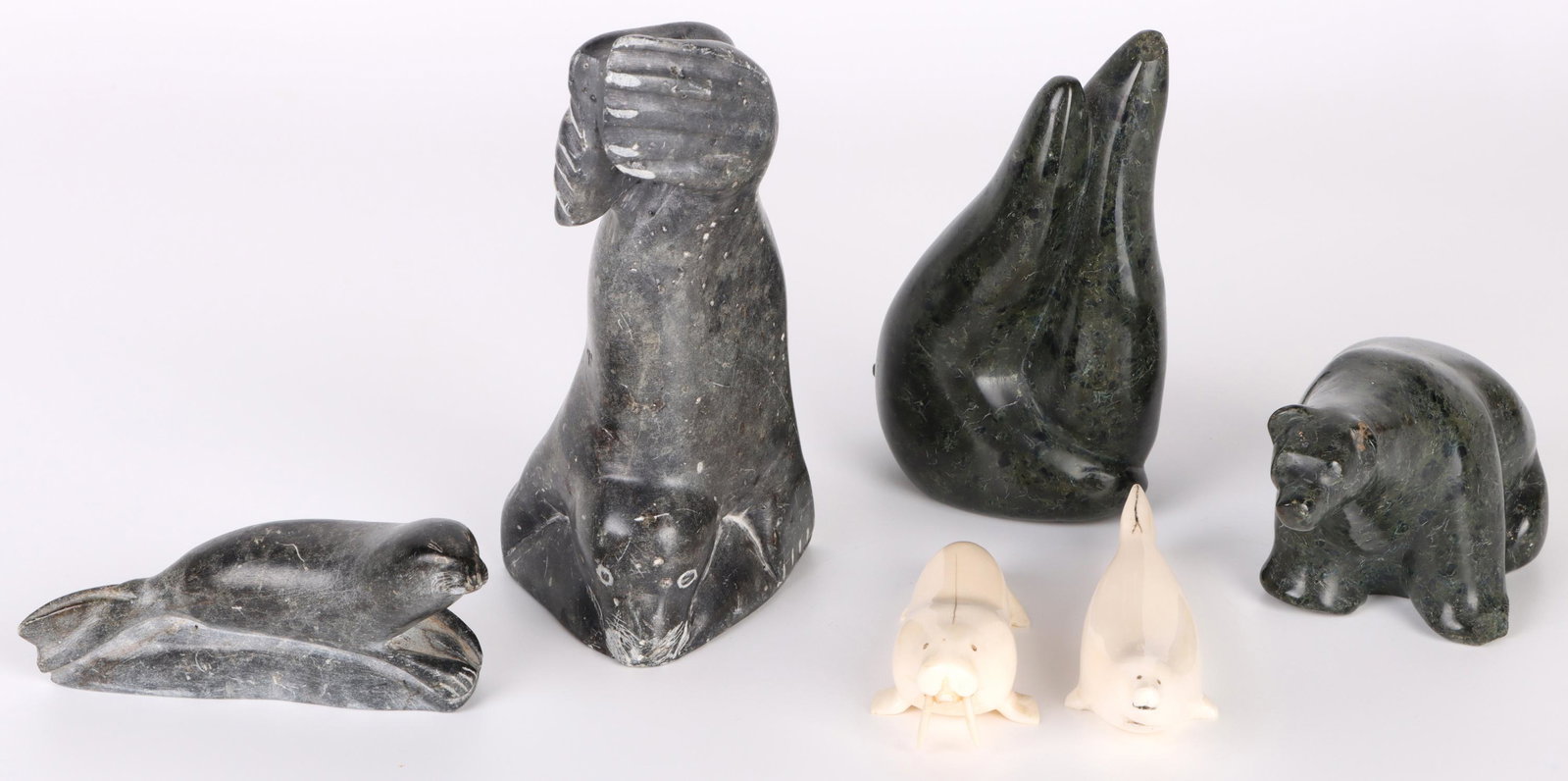 INUIT & ESKIMO CARVED STONE BEARS & WALRUSES: 140125 INUIT & ESKIMO CARVED STONE BEARS & WALRUSES Inuit and Eskimo handmade carved stone bears and walruses. To include four bear and walrus carved stone animal figures and two carved bone walruses,