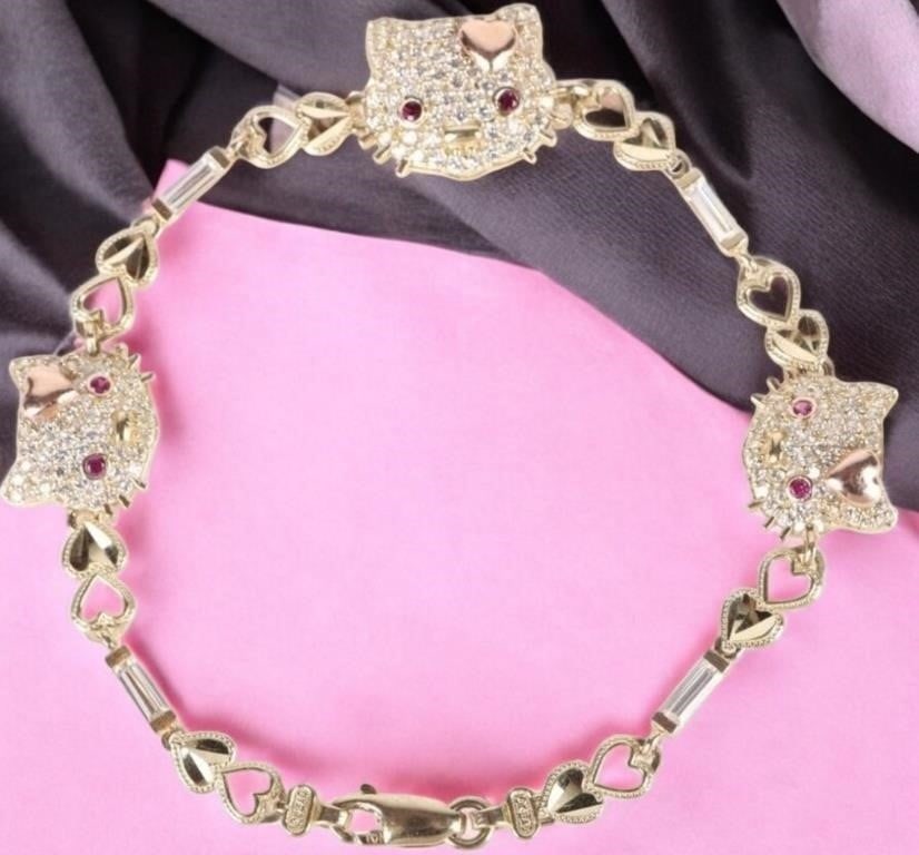 10K YELLOW GOLD HELLO KITTY RUBY CZ BRACELET: 10k yellow gold Hello Kitty ruby cubic zirconium ladies bracelet with six 0.02ct round rubies. Stone Type: Assorted Weight: 11.0 Grams Size: 8.0" length Condition: Very fine.