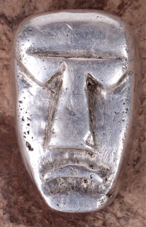 75.7 GRAMS FINE SILVER BULLION WITH TRIBAL FACE: 75.7 grams of fine silver shaped into a tribal mask/face. Weight: 75.7 Grams Condition: Please refer to photos