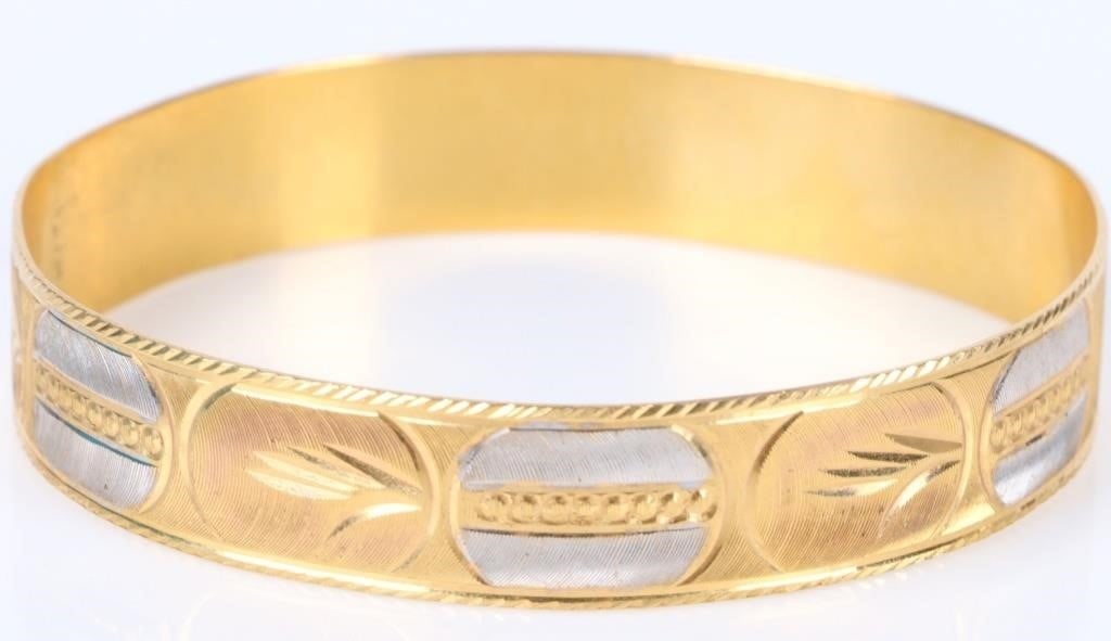 23K YELLOW GOLD ALTERNATING ENGRAVED LADIES BANGLE: 23K yellow gold alternating engraved ladies bangle to include a beautiful alternating white and yellow alternating engraved design. Weight: 22.93 Grams Size: 2.50" Condition: Very fine.