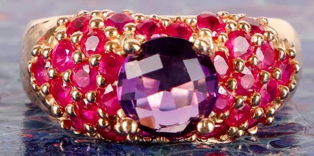 14K YELLOW GOLD RUBY AMETHYST LADIES RING: 14k yellow gold ruby amethyst ladies ring with one 2.0ct amethyst and twenty-nine 0.08ct round rubies.Stone Type: AssortedWeight: 8.71 gramsSize: US 9Condition: Very fine.