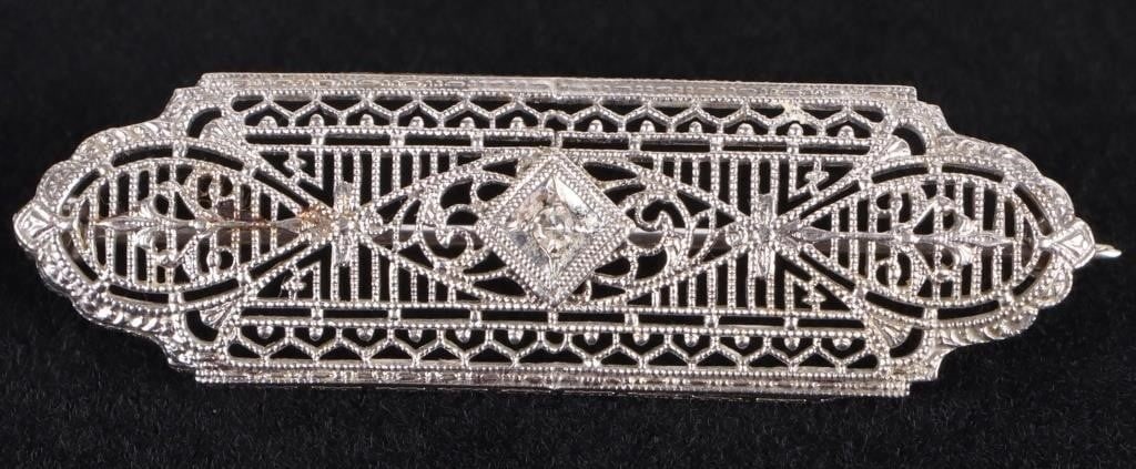 ART DECO ANTIQUE 10K WHITE GOLD DIAMOND BROOCH: Art Deco antique 10k white gold diamond ladies filigree brooch with one 0.02ct round diamond.Stone Type: DiamondWeight: 2.47 GramsSize: 1.75" lengthCondition: Very fine.