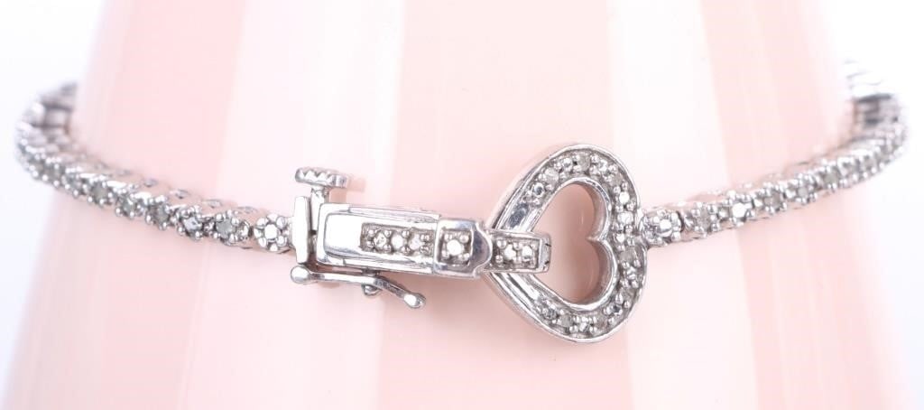 DIAMOND STERLING SILVER HEART TENNIS BRACELET: Diamond Sterling Silver Heart Bracelet. To feature tennis diamond design with heart lock. Stone Type: Diamond Weight: 8.82 grams Size: 7" length Condition: Very fine. See images.