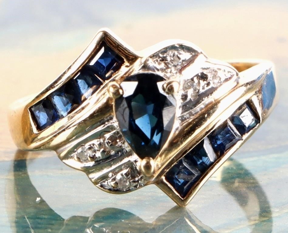 SAPPHIRE & DIAMOND LADIES RING IN 14K YELLOW GOLD: Sapphire & diamond ladies ring set in 14K yellow gold. This ring has a pear shaped sapphire center stone with channel set sapphires and round diamonds. Stone Type: Sapphire Weight: 2.70 Grams Size: 5.