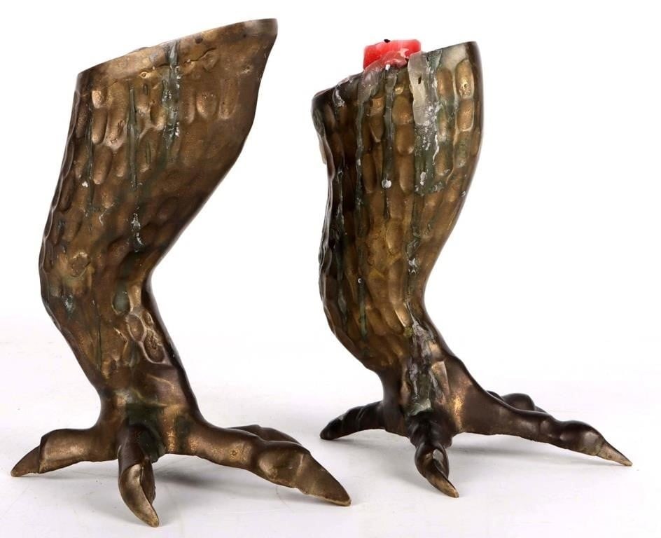 CLAWED CHICKEN FOOT BRASS CANDLESTICK: Clawed chicken foot brass candlestick. Candle and wax remnants are still on the piece but it can be cleaned on request.Size: 6.5 X 6 X 5" eachCondition: See pictures. Covered in wax but can be cleaned