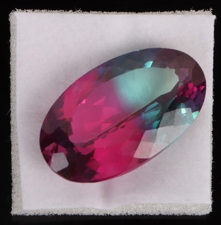 20.40 CT. BI-COLOR NATURAL SAPPHIRE W/ AGL: 21.90 ct. bi-color natural sapphire w/ AGL to include 1 excellent oval cut gemstone. Colors within the gemstone to include pink, and green. Testing revealed correspondence to the origin of the gemston