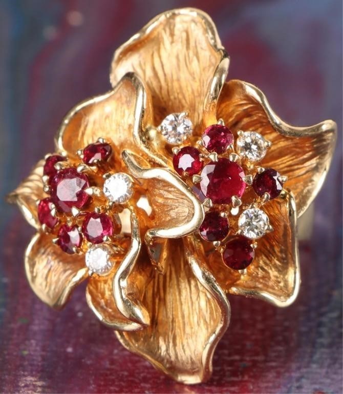 VINTAGE 18K GOLD RUBY & DIAMOND COCKTAIL RING: Vintage 18K yellow gold ruby and diamond ladies cocktail ring. The ring showcases a nature inspired, multi-flower design with textured, layered gold petals. The rubies and diamonds make up the center