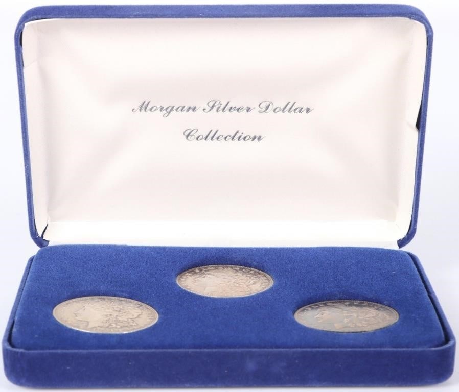 1921 MORGAN DOLLARS ONE HAS RAINBOW TONE (3): Lot of three 1921 Morgan fine silver dollars. One has mild rainbow toning throughout the obverse. The pieces are contained in an American Historical Society blue velvet case.Weight: 2.824 OZCondition: