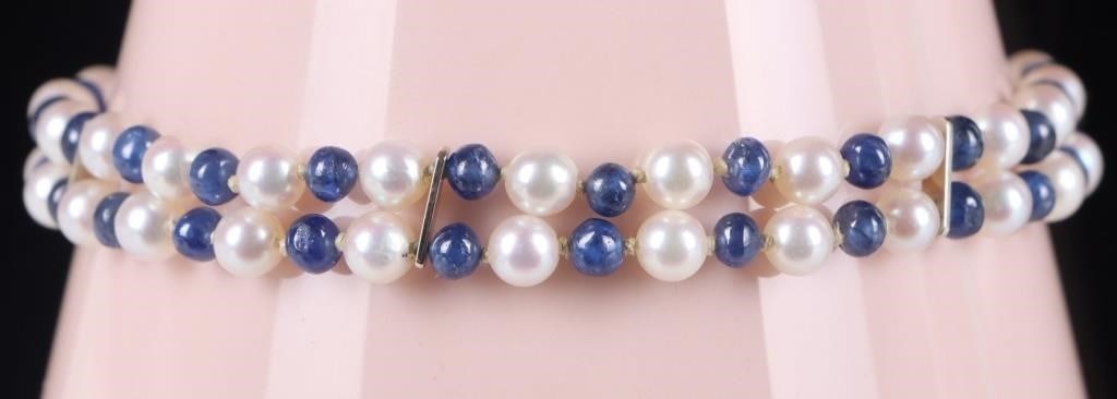 ANTIQUE 14K YELLOW GOLD SAPPHIRE PEARL BRACELET: Antique ladies bracelet with a 14k yellow gold clasp and braces, 52 seed pearls, and 43 polished blue sapphires. eight of those pearls and one of those sapphires are arranged in a floral pattern on