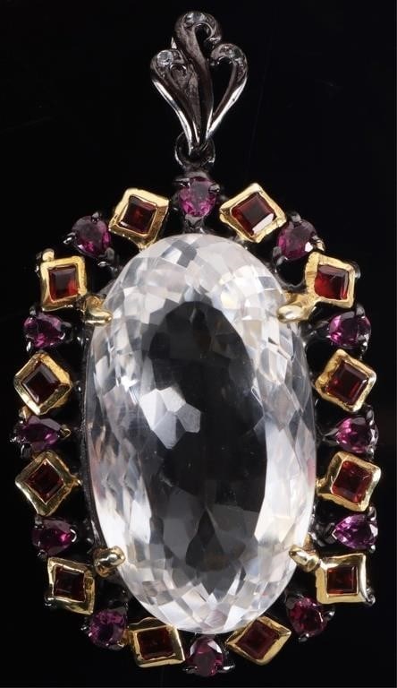 STERLING SILVER LADIES PENDANT W/ 54CT QUARTZ: Sterling silver ladies pendant with a 54ct quartz center gemstone surrounded by an alternating pattern of rhodolite and tanzanite gemstones. There is gold plating surrounding the rhodolite gemstones