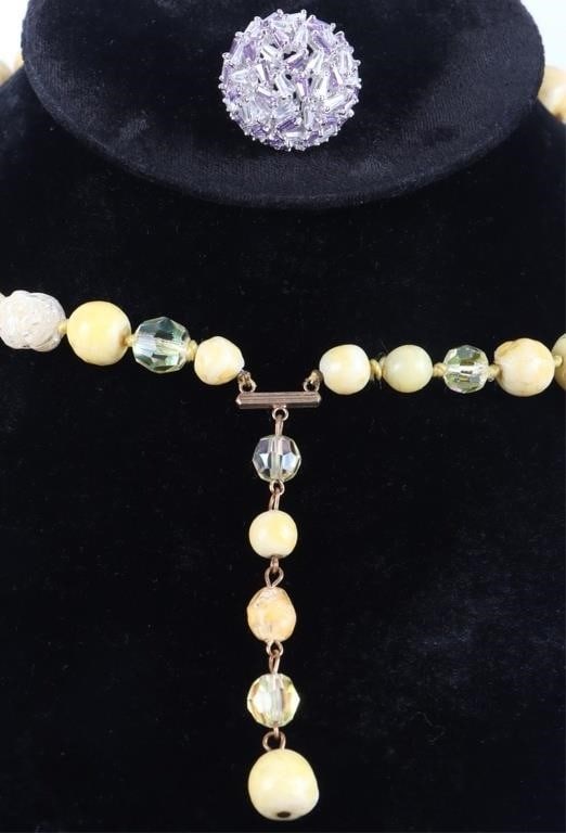 BEADED NECKLACE AND JEWEL-ENCRUSTED RING LOT: Lot of two pieces of ladies jewelry, to include one beaded necklace with an alternating pattern of polished glass, tough yellow stones, and rough transparent stones as well as gold-tone clasps, and a