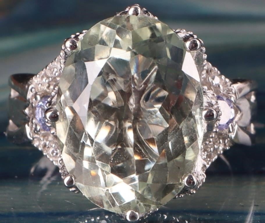 ~5CT OVAL PRASIOLITE, WHITE TOPAZ & TANZANITE RING: ~5.0CT oval prasiolite ( green amethyst), white topaz and tanzanite ladies cocktail sterling silver ring. This design is a variation of a three stone ring with the two accent tanzanite stones on the s