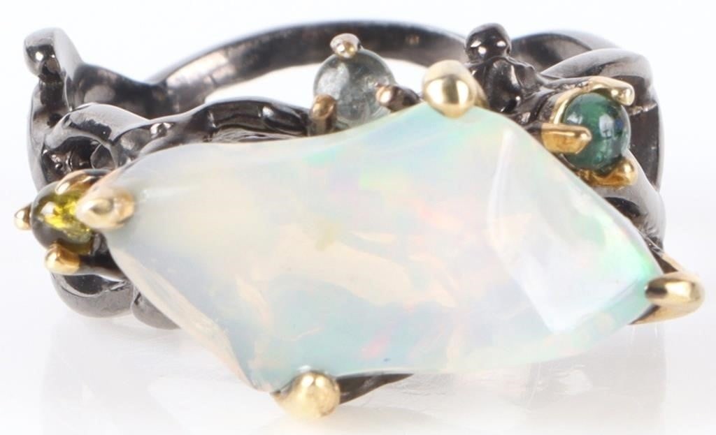 STERLING SILVER LADIES RING W/ NATURAL OPAL: Sterling silver ladies ring with a large natural oval center stone, two tourmaline and one spinel accessory stone, and a band molded like a braided branch. The piece is gold-plated on the prongs and b