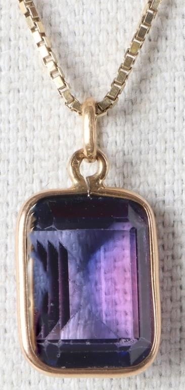 18K NECKLACE WITH 15MM PURPLE SAPPHIRE PENDANT: 18K yellow gold necklace with 15MM purple sapphire pendant. The necklace is a 24" box chain with a cushion cut purple sapphire pendant outlined in a simple gold setting accenting the gemstone.Stone Ty