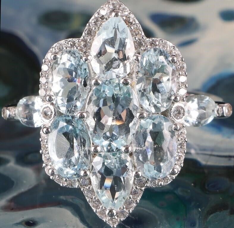 VINTAGE- STYLE AQUAMARINE ENGAGEMENT RING: Vintage-style aquamarine cluster engagement ring set in sterling silver. This beautiful ring is characterized by a marquise shape created by the cluster of stones surrounded by a delicate halo of