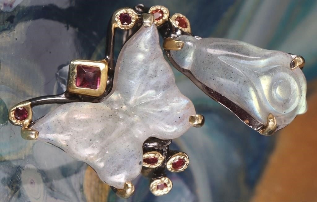 WHITE CARVED LABRADORITE STERLING SILVER RING: White carved floral and butterfly labradorite sterling silver gold-tone ladies ring with small peridot gemstones.Stone Type: AssortedWeight: 8.77 gramsSize: US 8Condition: New.
