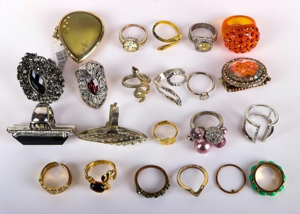 EXPRESSIVE AND ELABORATE LADIES RINGS LOT OF 22: Lot of twenty-two expressive and elaborate ladies rings. Of note are an orange piece covered in orange stones, a piece in the shape of a large teardrop with an articulated band, a gold-toned piece wit