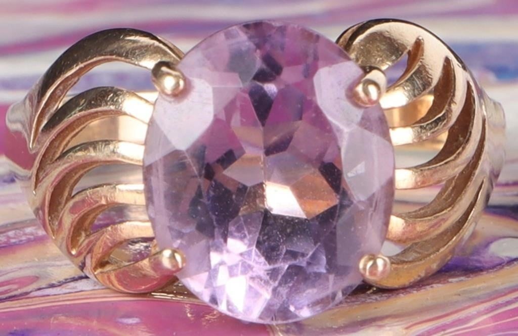 14K YELLOW GOLD LADIES RING W/ 7.5CT SPINEL GEM: 14k yellow gold ladies ring with a 7.5ct oval-cut purple spinel center gemstone. The shoulders feature broad swirling patterns.Stone Type: SpinelWeight: 4.5 gramsSize: US 8.75Condition: See pictures.