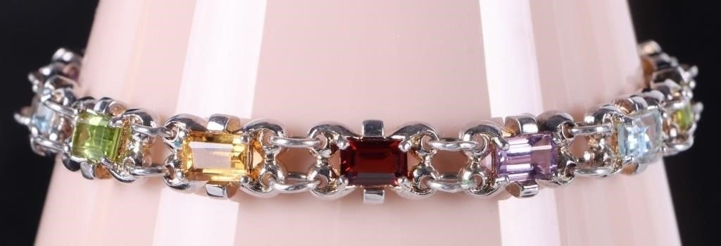 STERLING SILVER BRACELET W TOPAZ PERIDOT CITRINE +: Sterling silver ladies ring with thirteen 0.5ct rectangle-cut gemstones (two topaz and peridot, three amethyst, citrine, and garnet). The underside of the piece features gold-toning.Stone Type: Assort