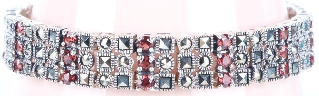 GLITTERING STERLING SILVER BRACELET W/ GARNET: Glittering sterling silver ladies bracelet studded with thirty-six small round-cut garnet gemstones and 116 small marcasite gemstones.Stone Type: GarnetWeight: 24.54 gramsSize: 8" longCondition: See p