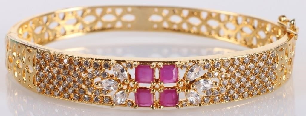 GOLD-TONED LADIES BRACELET WITH FOUR 0.37K RUBIES: Gold-toned ladies bracelet with four square-cut 0.37CT rubies arranged in a square surrounded by white stones.Stone Type: RubyCondition: See pictures.