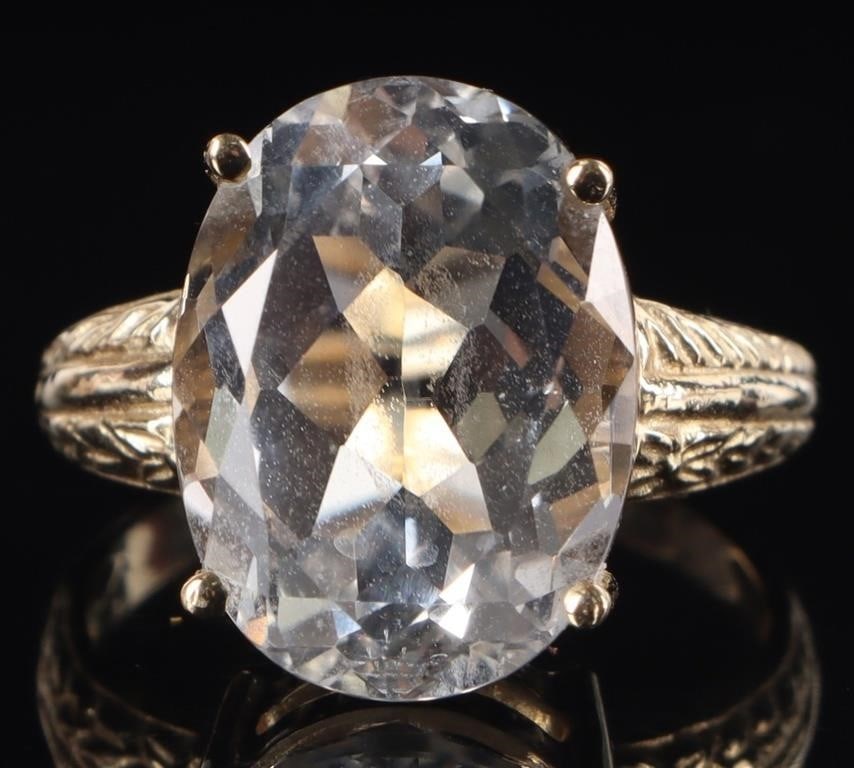 13CT BRIGHT OVAL TOPAZ 10K YELLOW GOLD LADIES RING: 10k yellow gold ladies ring with an approximately 13ct oval-cut bright topaz center gemstone. The shoulders feature laurel-shaped and diagonal etchings on the shoulders.Stone Type: TopazWeight: 6.11