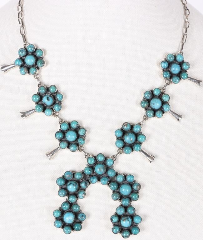 SW STYLE STERLING SILVER LADIES NECKLACE W/ TURQ: Southwest style sterling silver ladies necklace with multiple turquoise rosettes about the length, each of which feature a flute-like lily projection, and a horseshoe-shaped pendant.Stone Type: Turquo