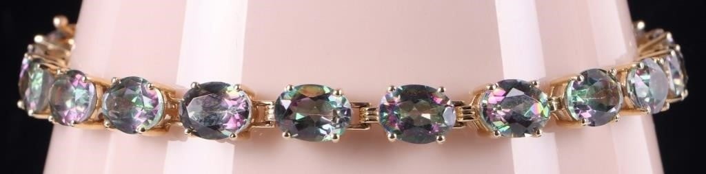 10K YELLOW GOLD LADIES BRACELET W/ TOURMALINE GEMS: 10k yellow gold ladies bracelet with twenty glittering medium-sized oval-cut tourmaline gemstones along its edge. Signed 'JH'. Stone Type: Tourmaline Weight: 15.41 grams Size: 8.5" long Condition: See