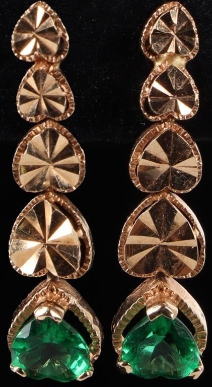 TSAVORITE 18K GOLD LADIES DANGLE EARRINGS: 18k yellow gold ladies heart dangle earrings. The bottom link features a green heart-cut tsavorite gemstone and the rest of the links feature gold hearts with bent sunburst patterns. One pushback is 1