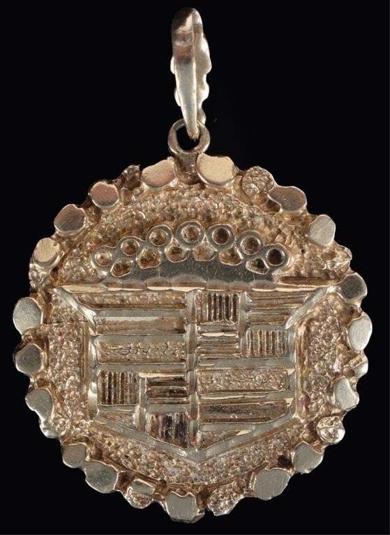 VINTAGE 14K YELLOW GOLD CADILLAC LADIES PENDANT: Vintage 14k yellow gold ladies pendant of the classic Cadillac logo with the crown. The circumference of the pendant is rock-textured. Weight: 7.51 grams Size: 2 x 1.5" Condition: See pictures