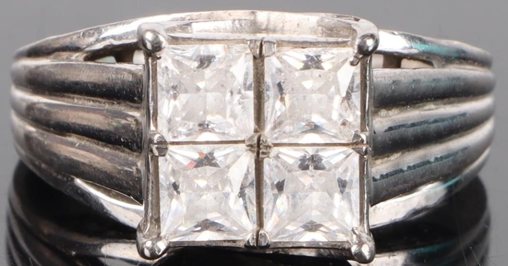 STERLING SILVER CUBIC ZIRCONIUM LADIES RING: Sterling silver cubic zirconium ladies ring. Gemstones to include four 0.46ct princess cut CZ, and thirty 0.01ct round cut CZ. Stone Type: CZ Weight: 7.07 Grams Size: 8.00 U.S. Condition: Little to no