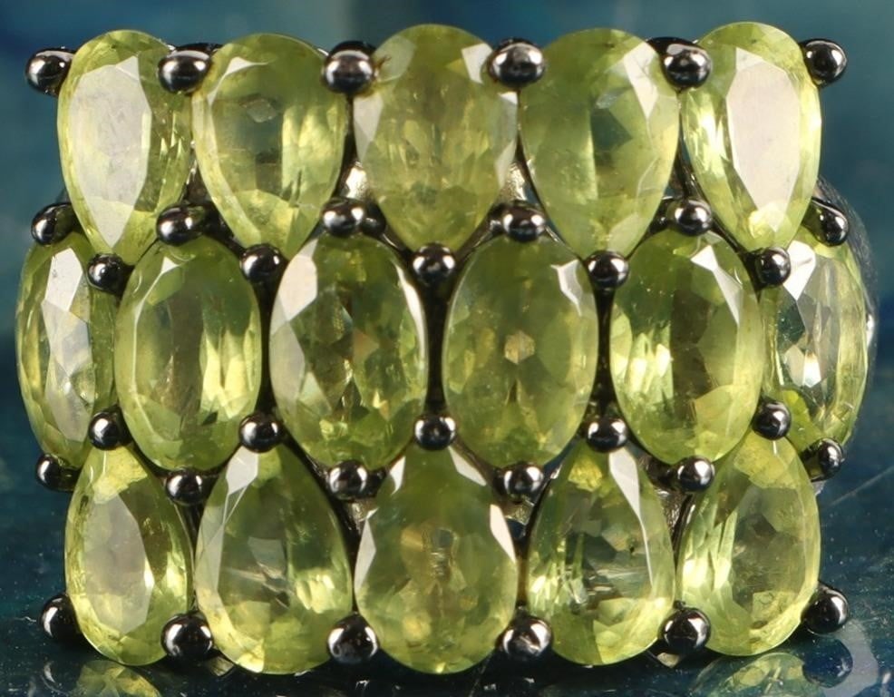 STERLING SILVER LADIES RING W/ 16 PERIDOT GEMS: Sterling silver ladies ring with sixteen peridot gemstones, ten 0.3ct pear-cut pieces on the outside rows and six 0.25ct oval-cut pieces on the inside row. Stone Type: Peridot Weight: 6.27 grams Size: