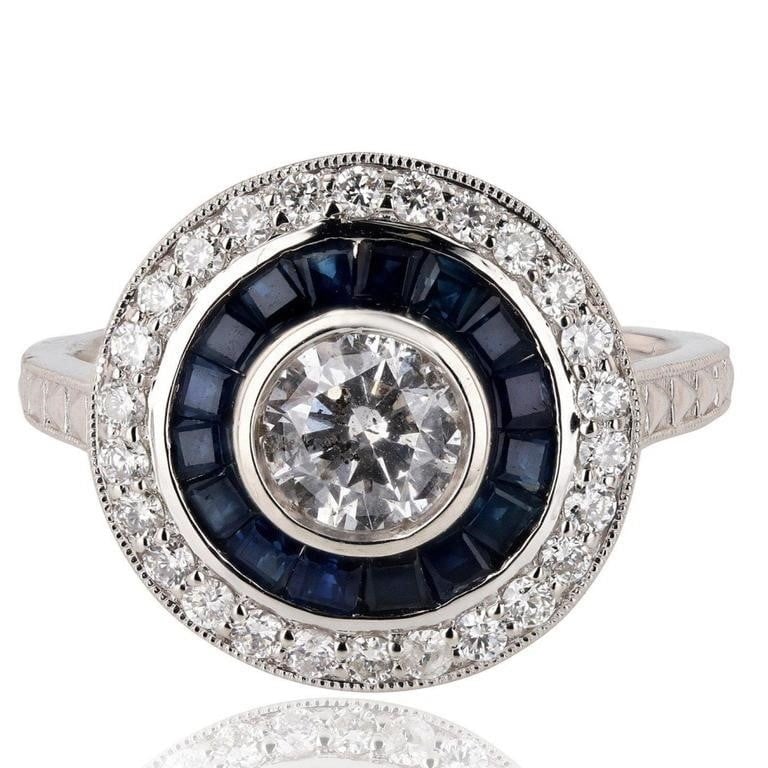 1.11CTW SAPPHIRE PLATINUM LADIES RING W/ DIAMONDS: DESCRIPTION: ONE PLATINUM LADY'S CUSTOM MADE DIAMOND & SAPPHIRE RING. 7.10 GR TW #1 â€“ MAIN CENTER GEMSTONE(S):# IDENTITY : ONE CENTER DIAMOND SET IN BEZEL SETTING STYLE; CARAT WEIGHT : 0.65 