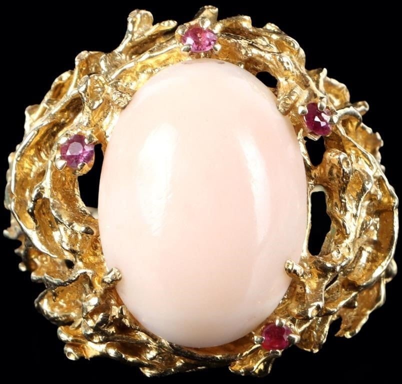 18K YELLOW GOLD BRUTALIST LADIES RING W MOMO CORAL: 18k yellow gold Brutalist-style ladies ring with a 18 x 12.9mm momo coral center stone surrounded by four 0.03ct round-cut pink sapphire gemstones. Stone Type: Sapphire & Coral Weight: 15.48 grams Siz