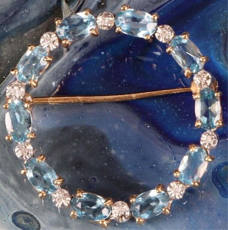 14K YELLOW GOLD LADIES BROOCH W/ TOPAZ & DIAMONDS: 14k yellow gold ladies brooch. This round piece features ten approximately 0.07ct oval-cut topaz gemstones around its circumference and ten melee diamonds positioned between them. The spaces around th