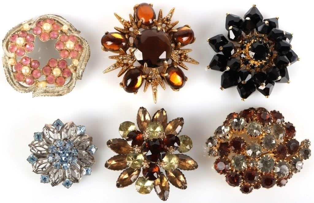 VINTAGE FLORAL RHINESTONE LADIES BROOCHES: Vintage rhinestone brooches in floral patterns lot of 6. Assorted variety in design and color between them. Size: 1.5 - 2" long Condition: Very fine.