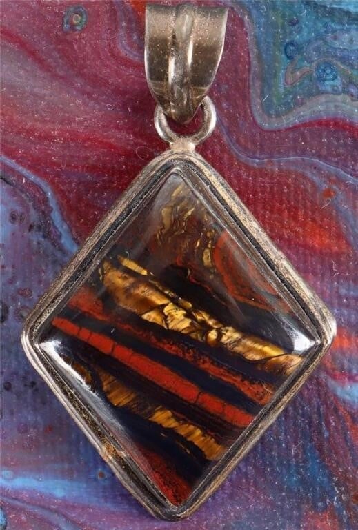 STERLING SILVER LADIES PENDANT W/ IRON TIGER'S EYE: Sterling silver ladies pendant with a large rhombus-shaped iron tigers eye stone. Stone Type: Tigers Eye Weight: 15.69 grams Size: 51.85 X 30.75 mm Condition: See pictures.