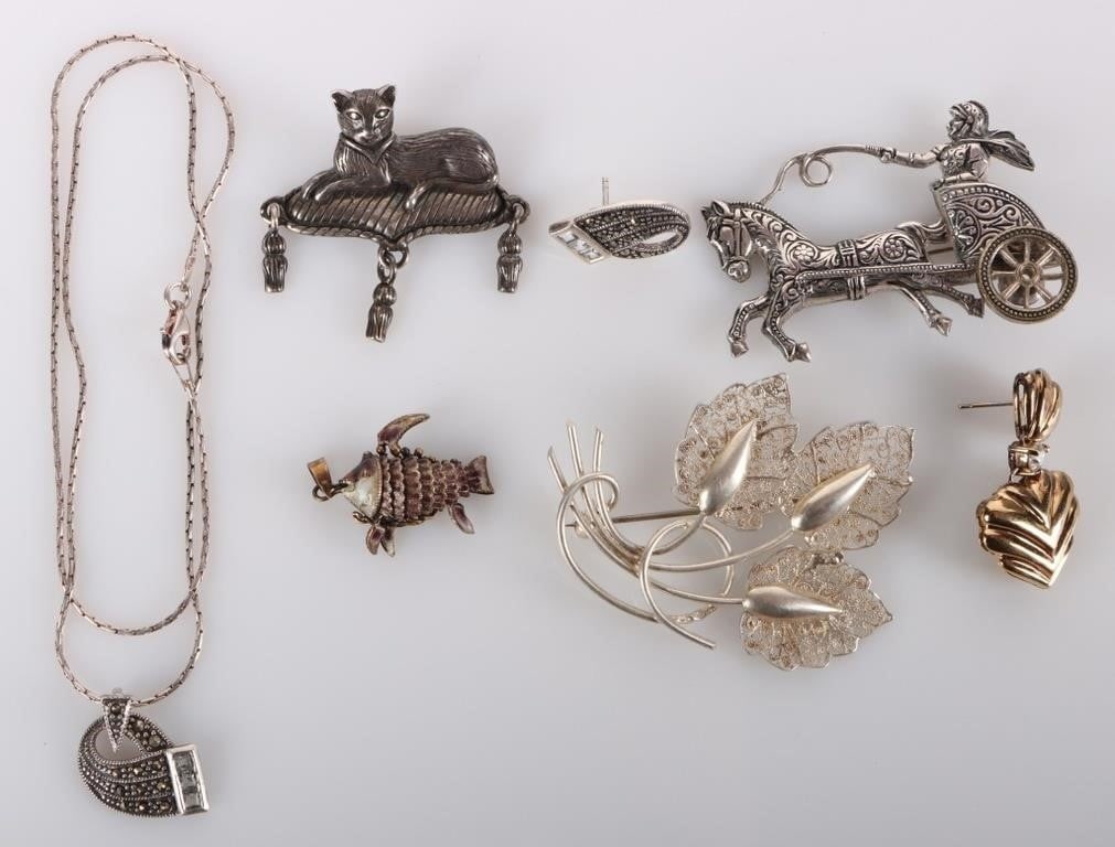 STERLING SILVER ORNATE LADIES JEWELRY - (7): Sterling silver ornate ladies jewelry to include: one matching pair of necklace and earrings, one gold-toned pendant, one filigree brooch, one ct brooch, one fish pendant, and one horse and carriage b